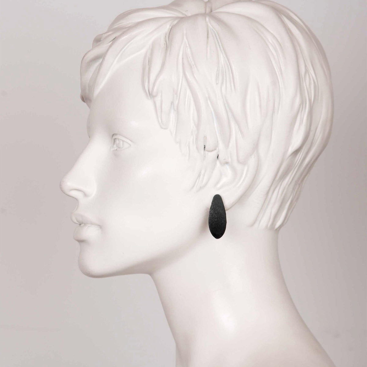 1. Side profile of mannequin wearing Tanel Veenre Mini Blackcurrants Earring with black velvety finish