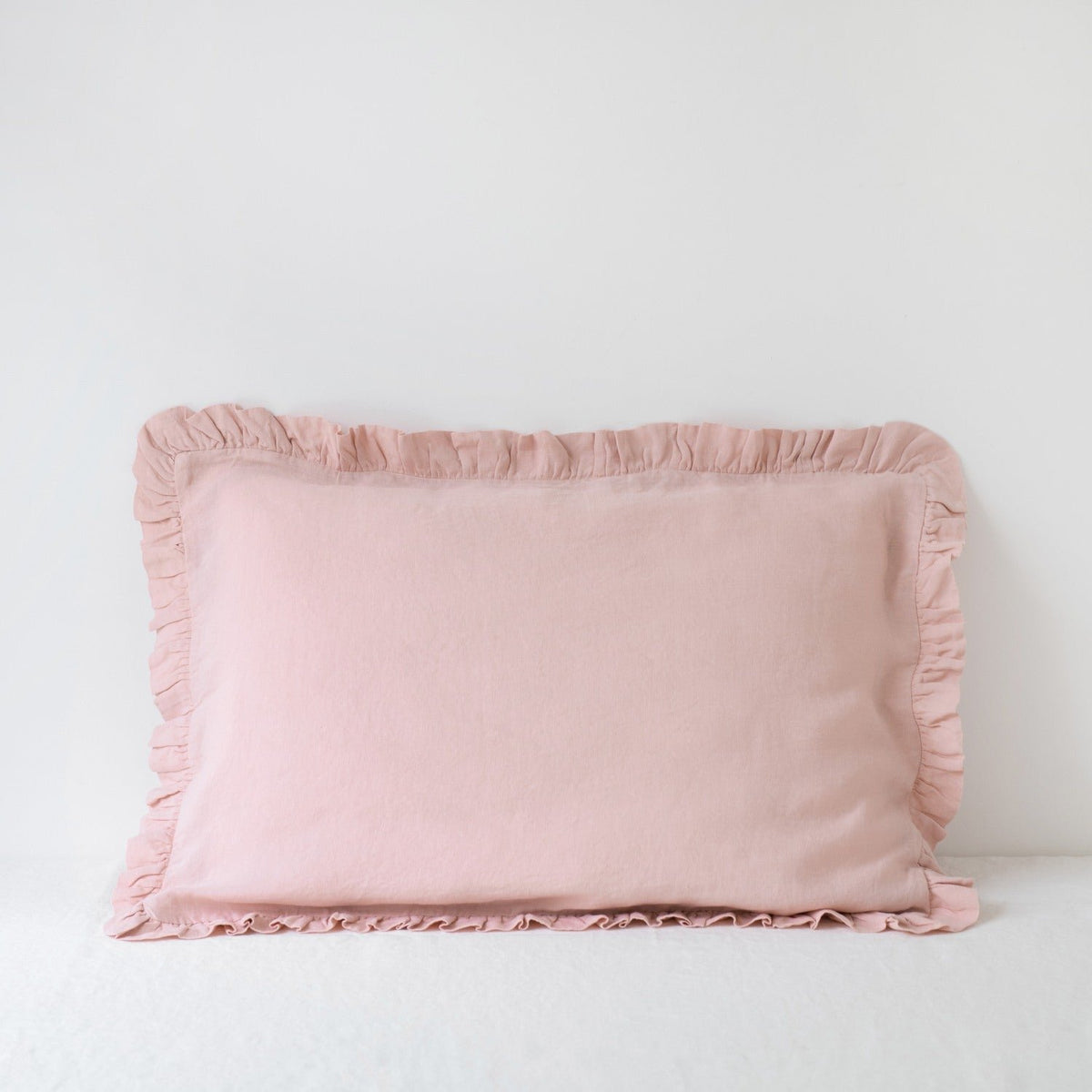 11. Pink linen pillowcase with frills on a white background, soft and romantic design
