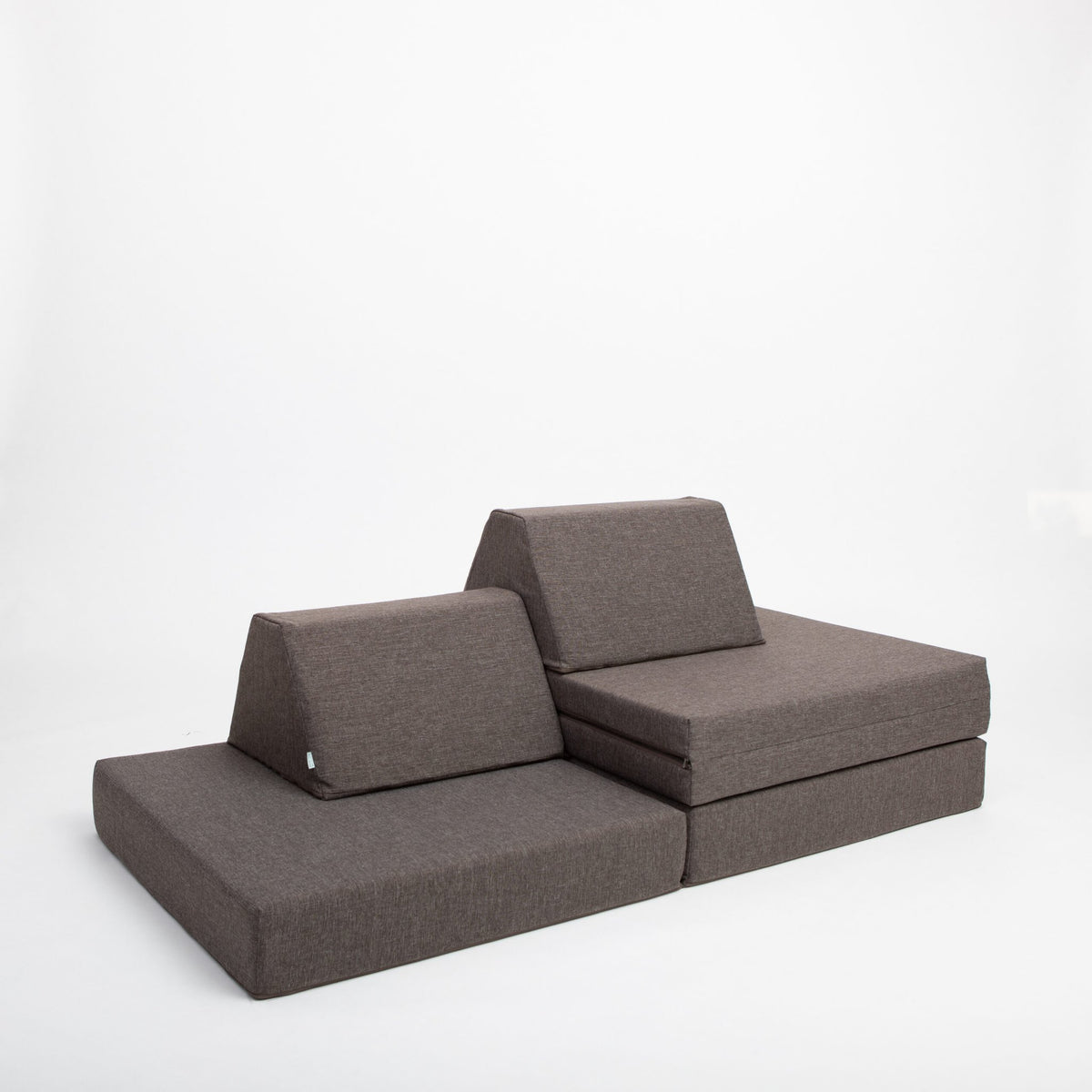 13. Monboxy dark brown play mattress set configured as a lounge chair in a studio
