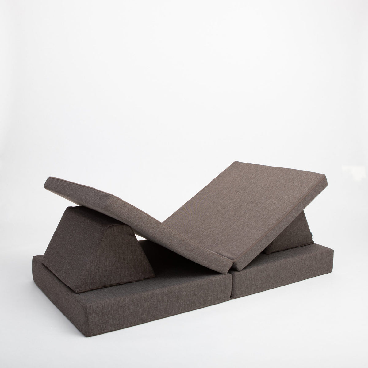 14. Monboxy dark brown play mattress set shown in a folded position in a studio