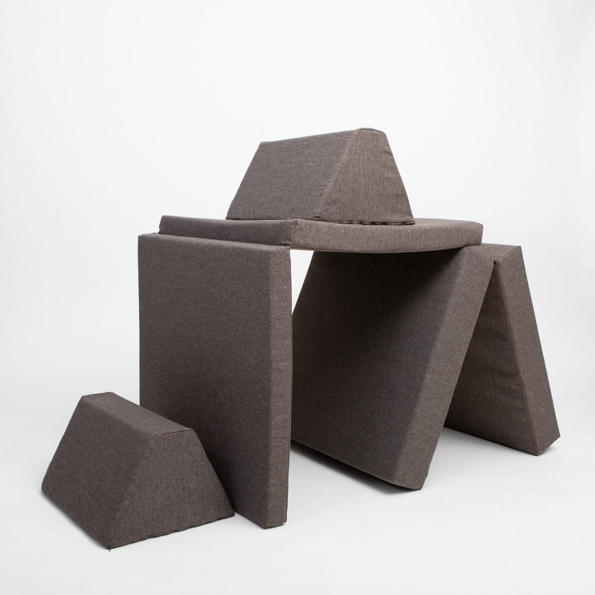 15. Monboxy dark brown play mattress set arranged as a fort in a studio