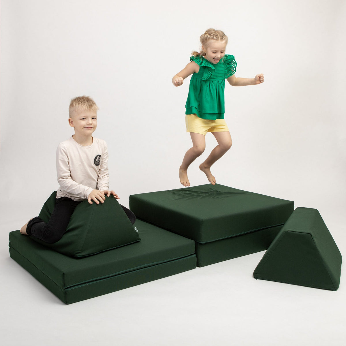 1. Two children playing on Monboxy deep green activity play mattress set in a studio setting