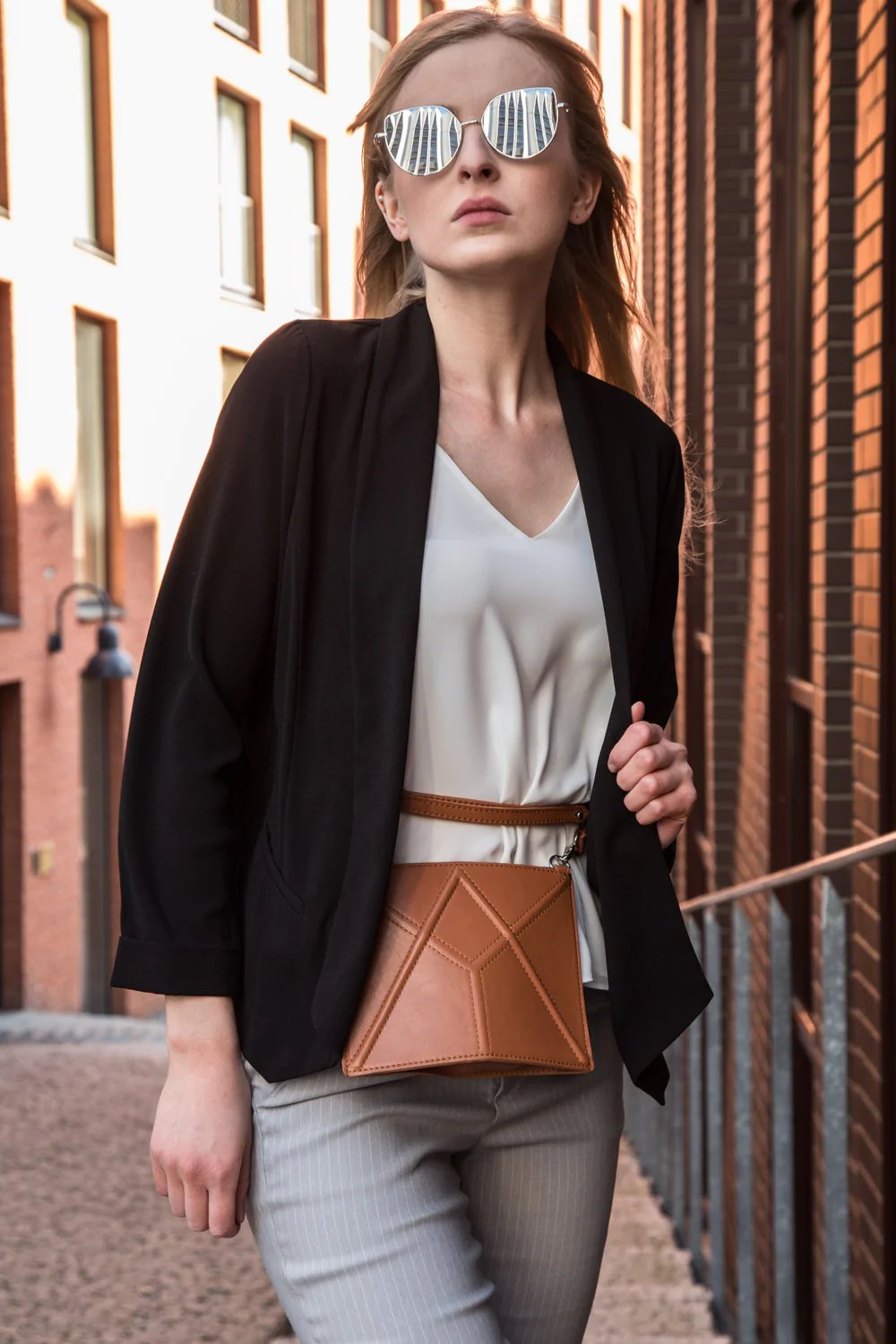 1. Women's brown FACET Mini leather waist bag by Gerda Retter Design, styled with black blazer and sunglasses in urban setting