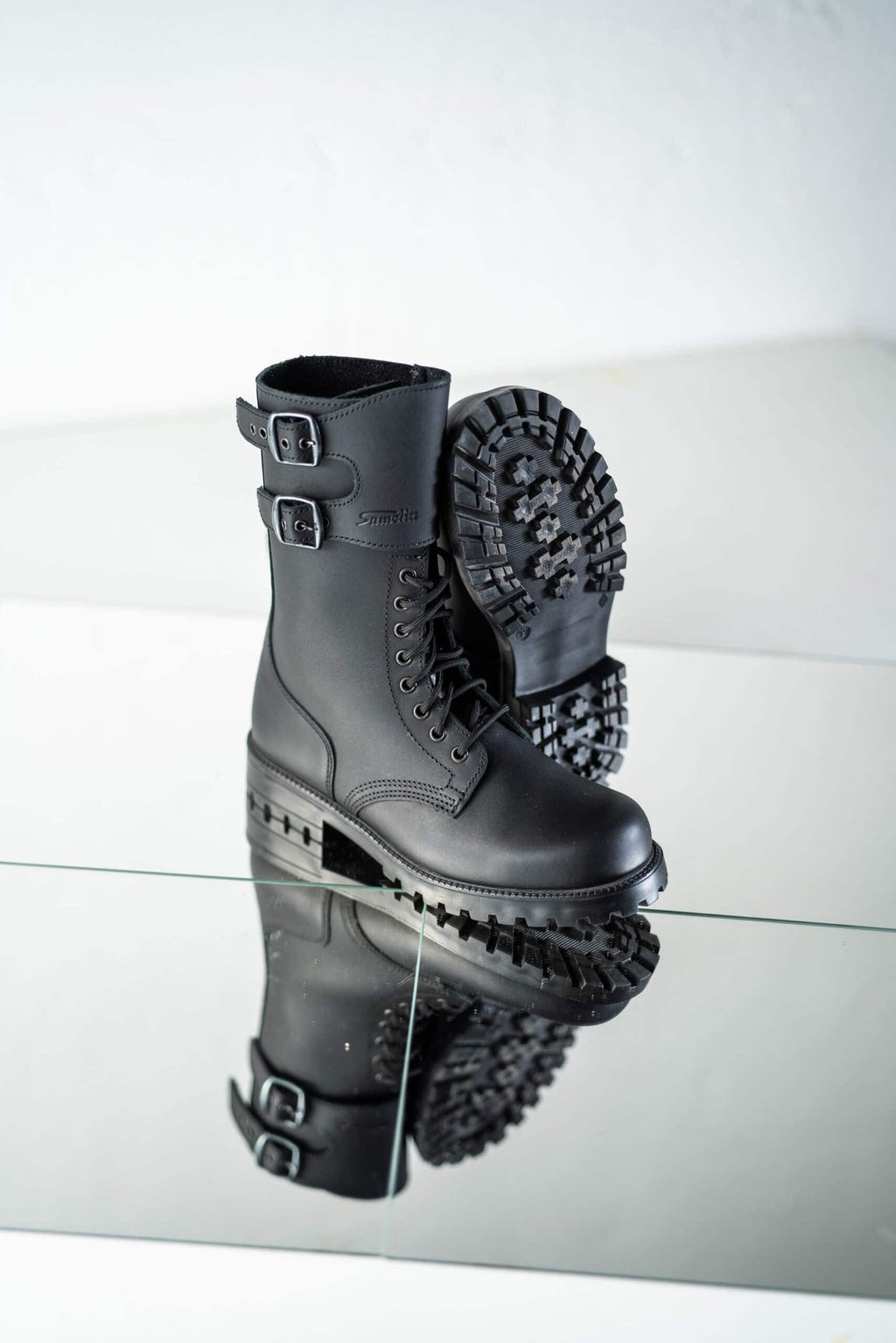 2. Unisex black Tarkovsky boots by Samelin shown in studio with reflective surface, highlighting design and sole