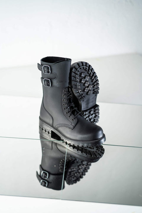 2. Unisex black Tarkovsky boots by Samelin shown in studio with reflective surface, highlighting design and sole