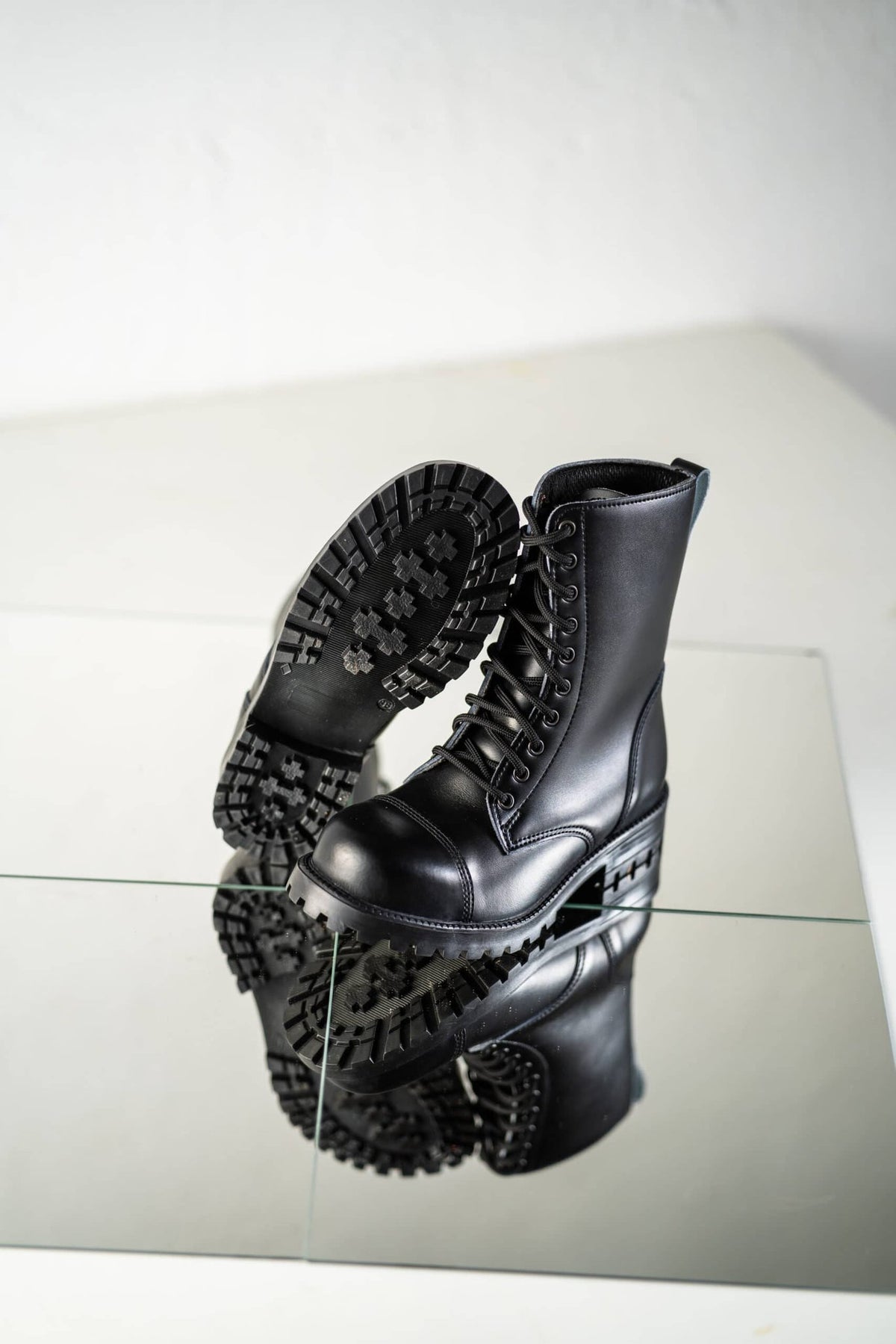 6. Samelin 511 Black boots on reflective surface, highlighting sole traction and leather texture