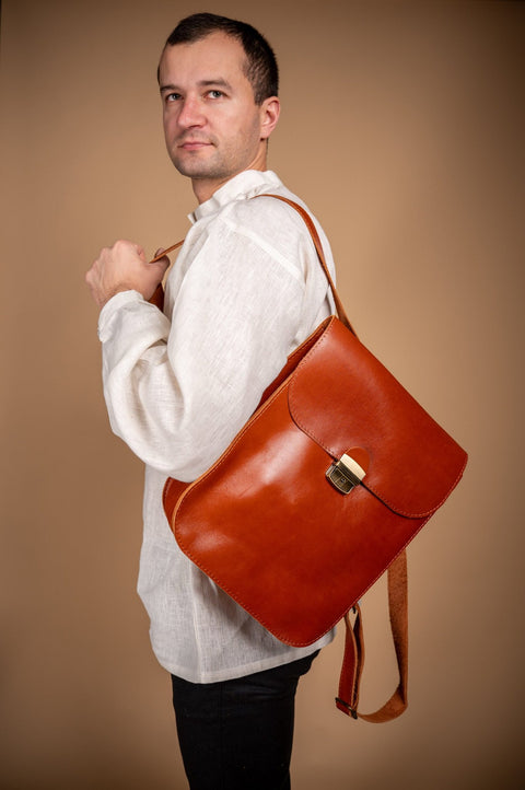 4. Man wearing Zelma Kraft natural leather saddle backpack in light brown, studio setting