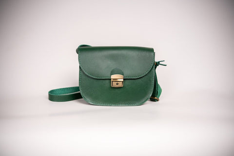 3. Studio shot of Zelma Kraft green leather saddle bag with buckle closure and adjustable strap
