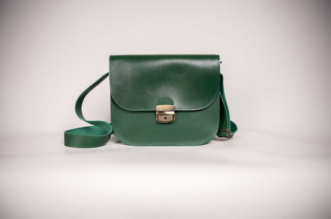 3. Studio shot of Zelma Kraft green leather saddle bag with adjustable strap and buckle closure
