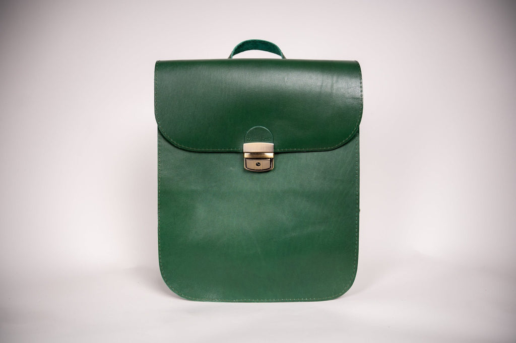 3. Studio shot of Zelma Kraft green leather saddle backpack, showcasing minimalist design and semi-glossy finish