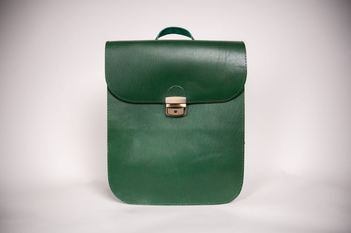 3. Studio shot of Zelma Kraft green leather saddle backpack, showcasing minimalist design and semi-glossy finish