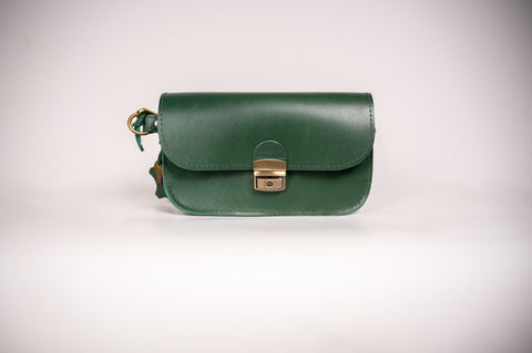3. Studio shot of Zelma Kraft green leather saddle bag mini, highlighting buckle closure and compact design