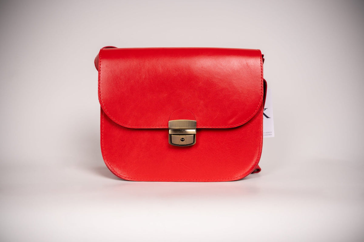 6. Front view of Zelma Kraft red natural leather saddle bag with semi-gloss finish and buckle closure