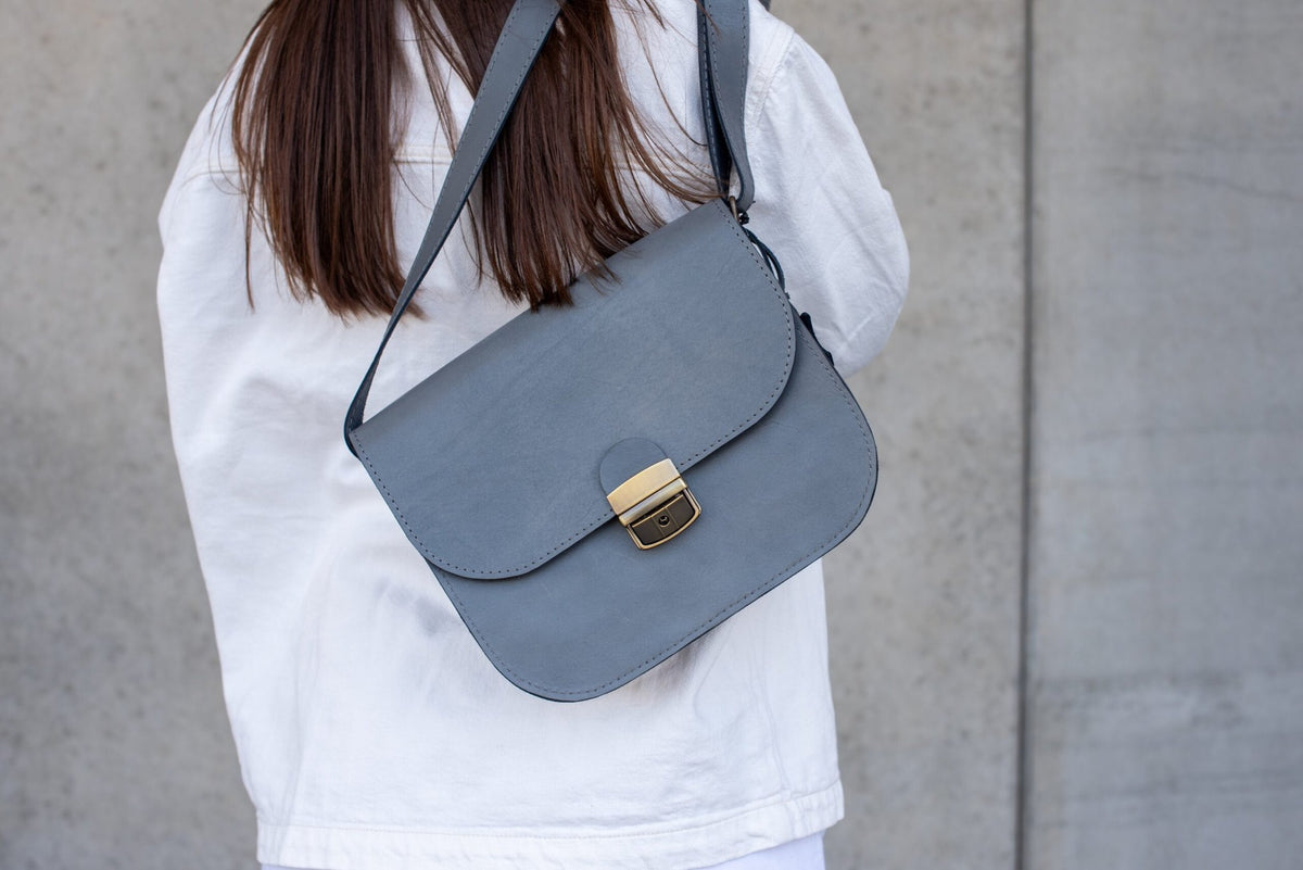 7. Close-up of Zelma Kraft grey leather saddle bag with adjustable strap and buckle closure