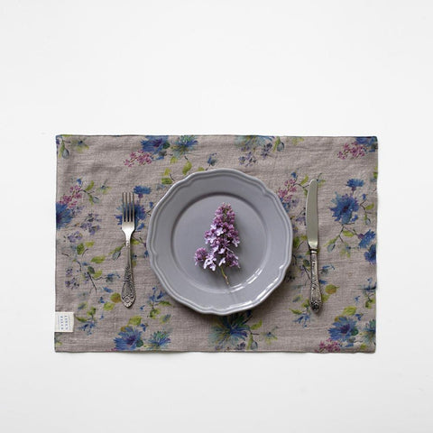 2. Dark floral linen placemat with a purple flower on a grey plate, set with a fork and knife