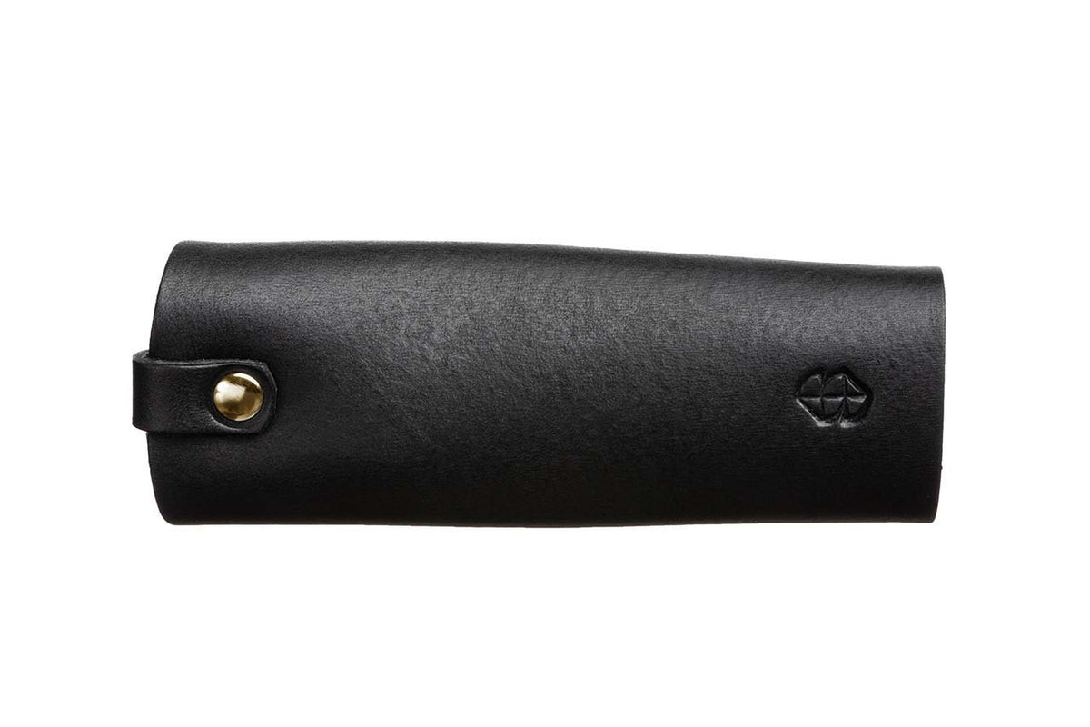 4. Black leather key holder by Stella Soomlais with embossed logo, shown from side on white background