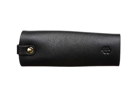 4. Black leather key holder by Stella Soomlais with embossed logo, shown from side on white background