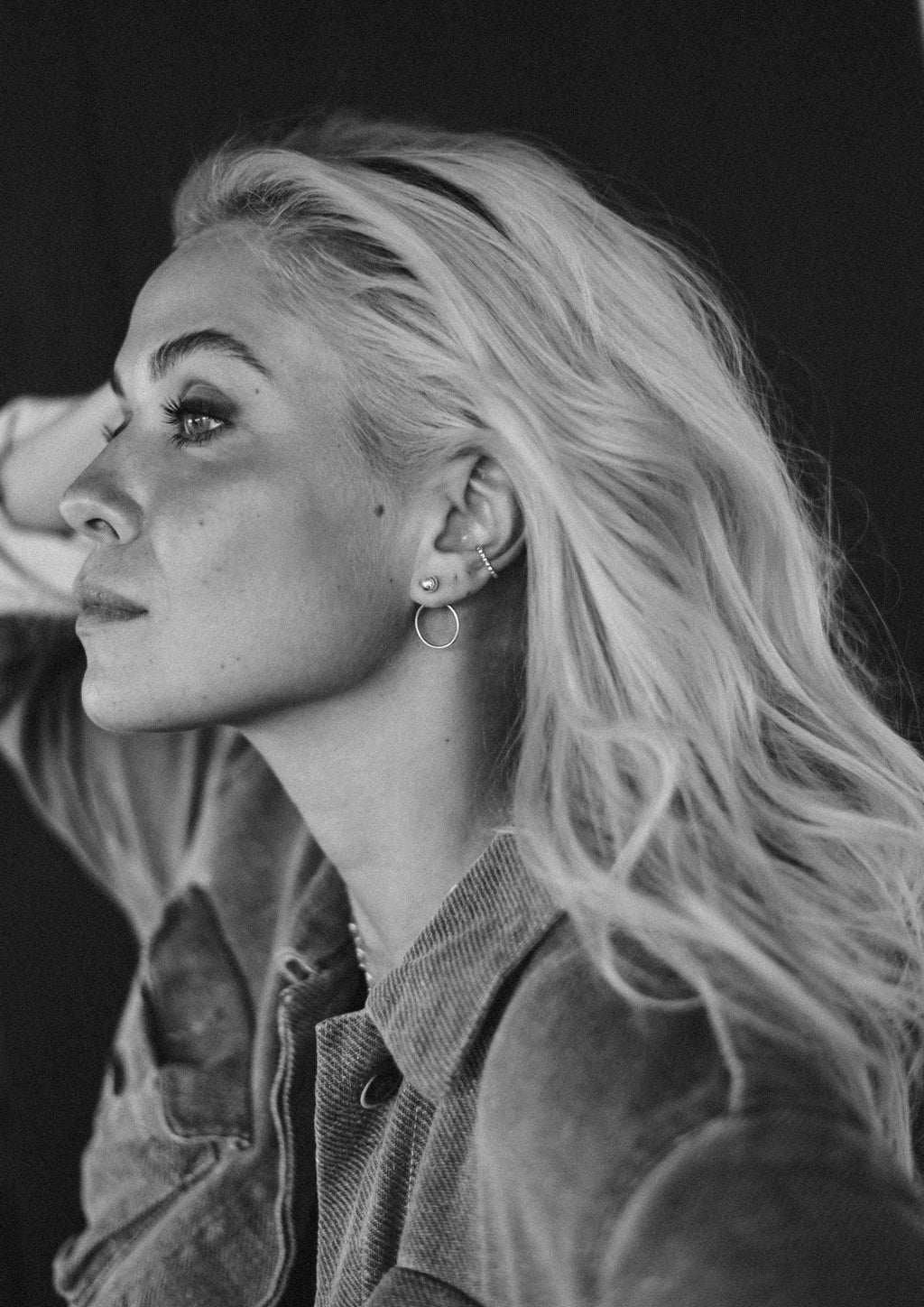 1. Woman wearing NO MORE Chord Earrings in silver, showcasing front-facing design with ball and circle, lifestyle setting