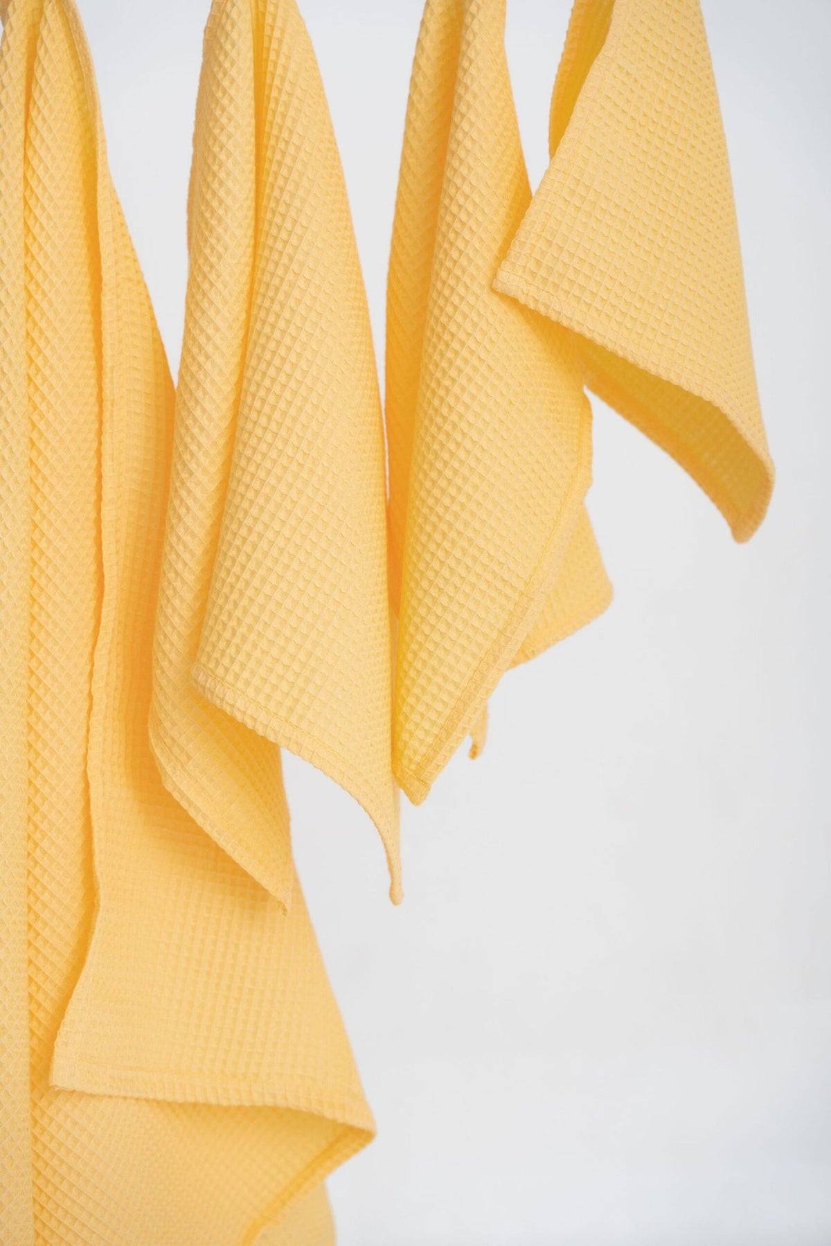 5. Detail of yellow organic waffle cotton towels, focusing on texture and fabric quality