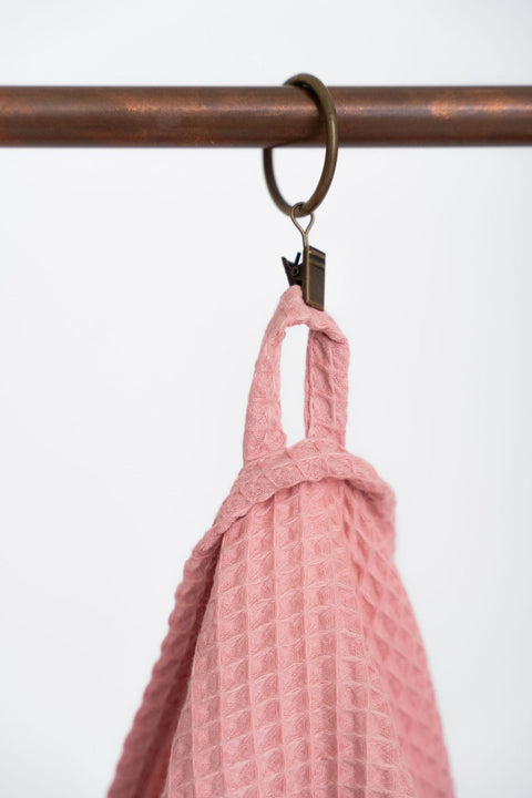 3. Close-up of peach waffle cotton towel hanging from a metal ring, highlighting texture and hanging loop
