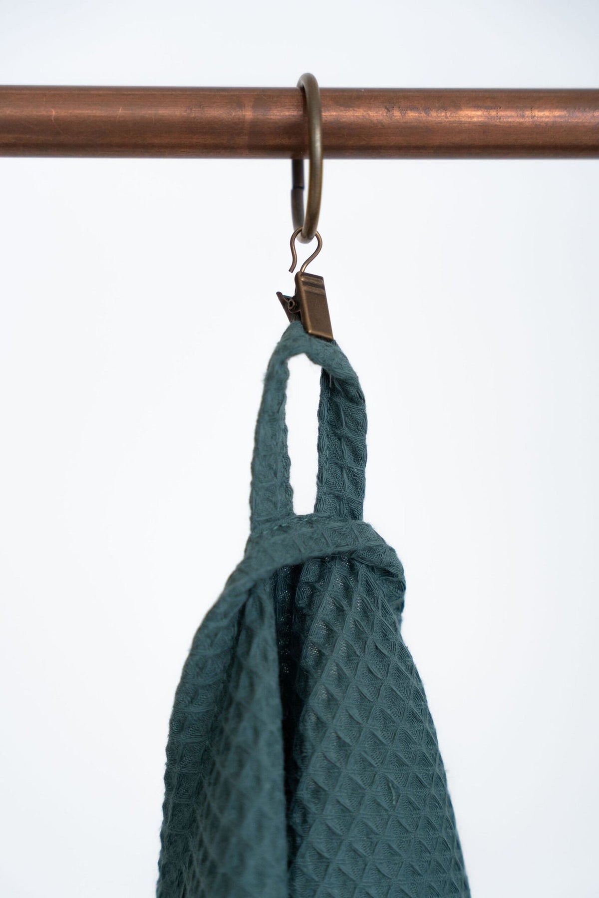 4. Detail of hanging loop on petrol organic waffle cotton towel on copper rack