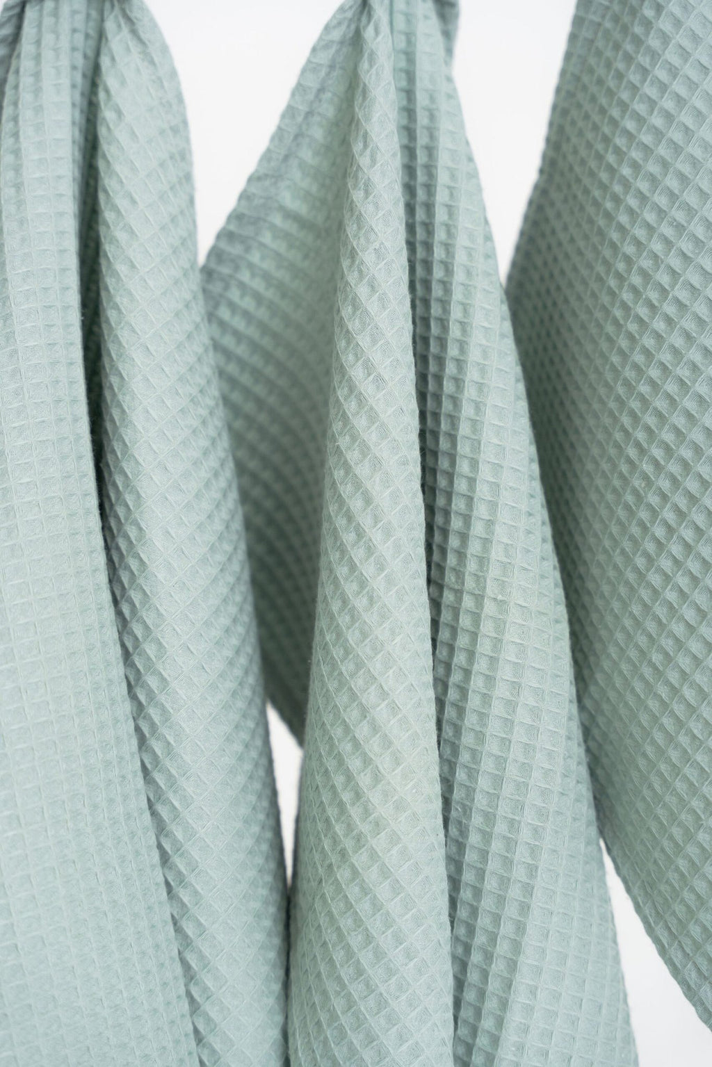 3. Close-up of sage green waffle cotton towels showing texture and weave pattern