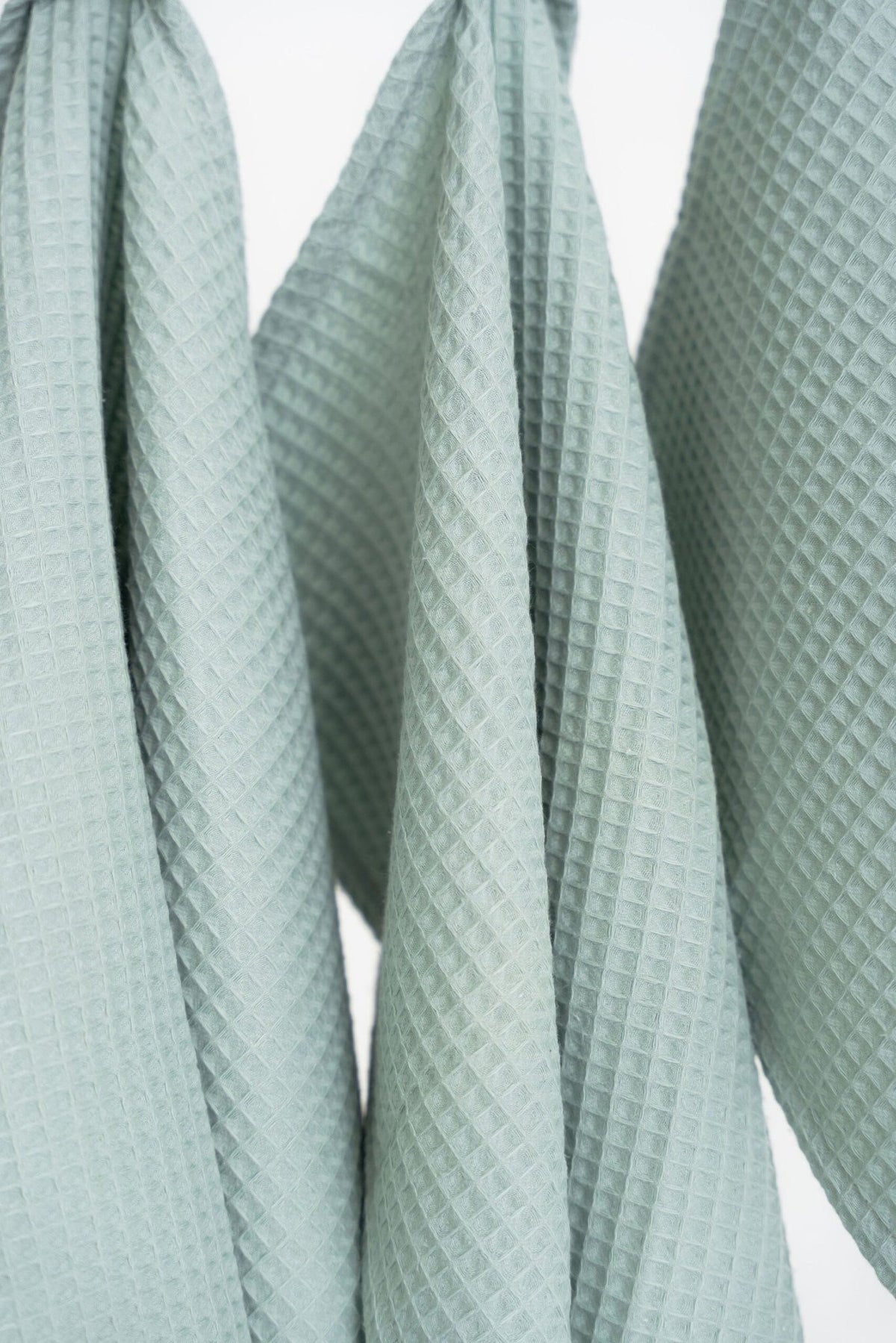 3. Close-up of sage green waffle cotton towels showing texture and weave pattern