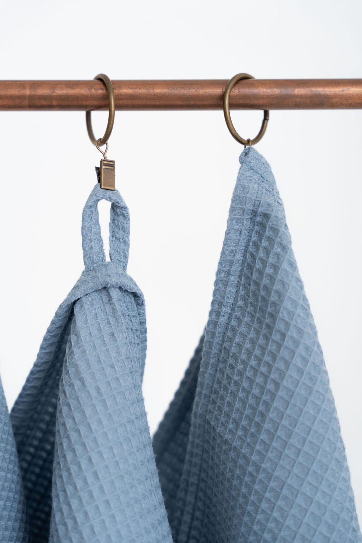 4. Close-up of blue waffle cotton towels on copper rod, focusing on texture and hanging loops