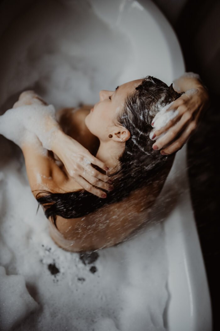 1. Woman using V.O.H solid shampoo in a relaxing bath setting