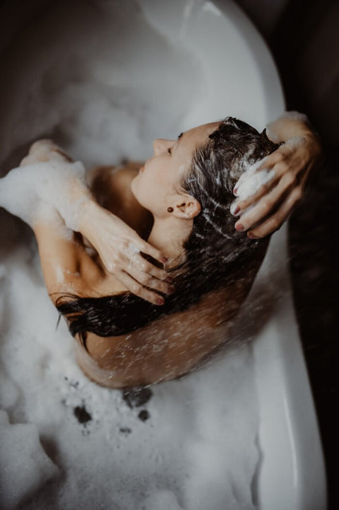 1. Woman using V.O.H solid shampoo in a relaxing bath setting