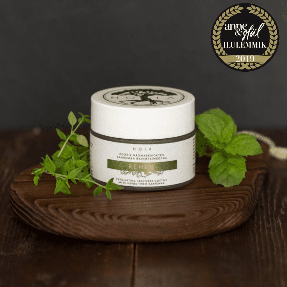 1. HOIA homespa Rehab Exfoliating Face Mask 50ML displayed on wooden tray with fresh herbs, award-winning skincare product