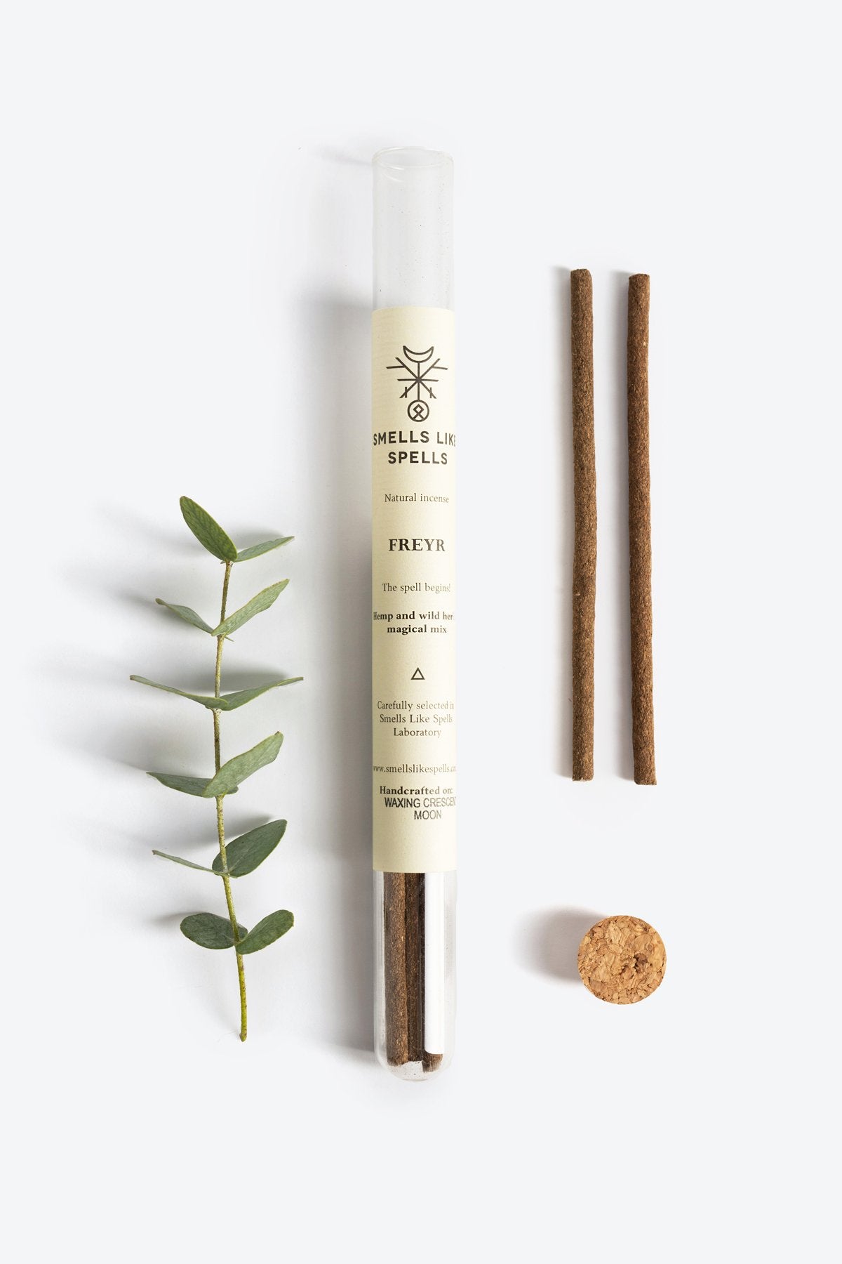 3. Smells Like Spells FREYR incense tube with two sticks, cork stopper, and green sprig on white background