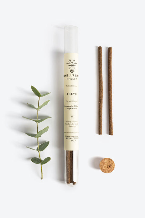 3. Smells Like Spells FREYR incense tube with two sticks, cork stopper, and green sprig on white background