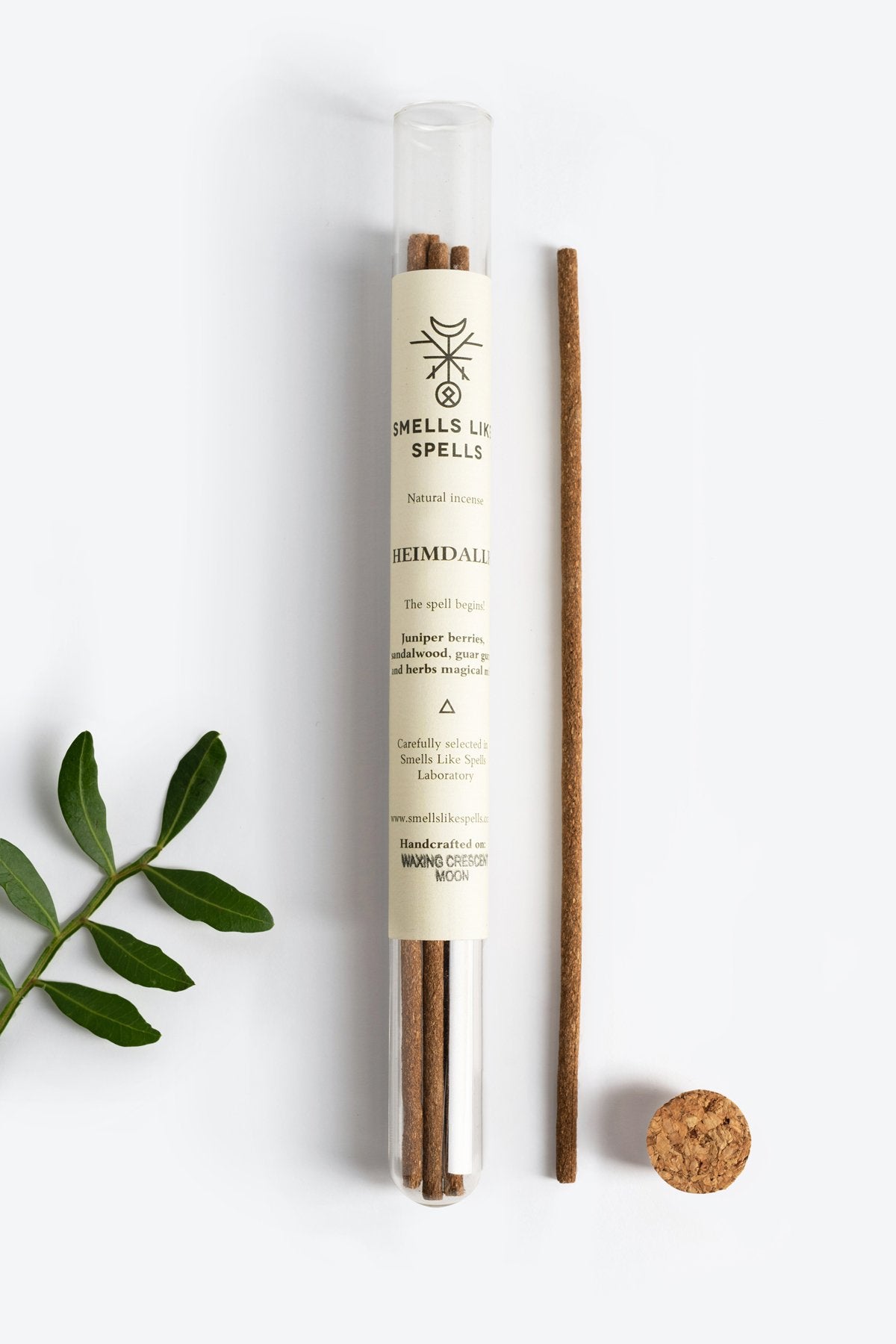 1. Smells Like Spells Natural Incense HEIMDALLR in glass tube with cork, featuring protective and uplifting aroma, shown with green leaves