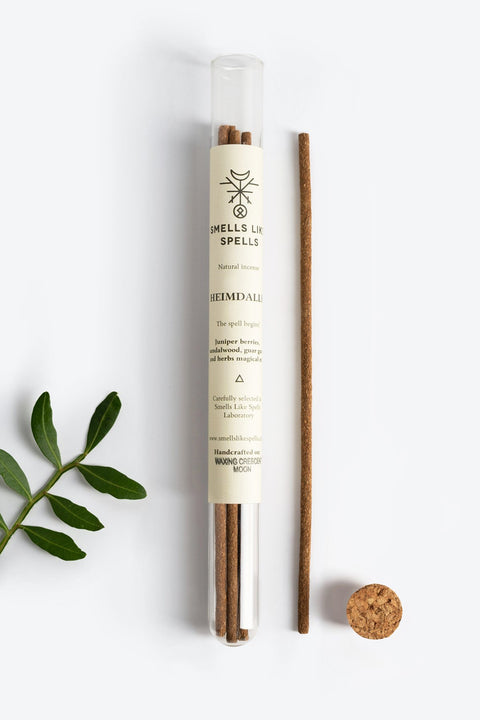 1. Smells Like Spells Natural Incense HEIMDALLR in glass tube with cork, featuring protective and uplifting aroma, shown with green leaves