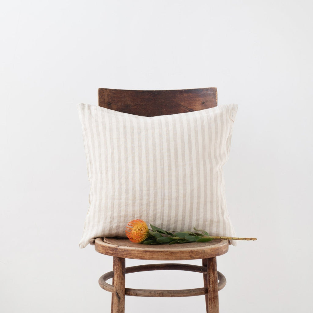 10. Natural stripe Linen Tales cushion cover on a wooden chair with an orange flower