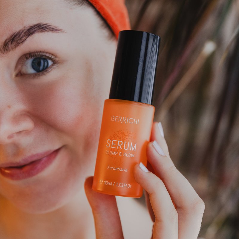 1. Woman holding Berrichi Plump & Glow moisturizing serum, 30ml, showcasing product in lifestyle setting