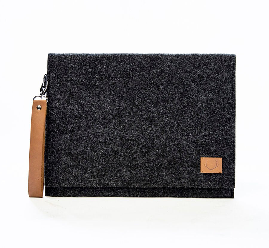 3. Studio image of Nordhale Berg black laptop bag with brown wristband, showcasing minimalist design