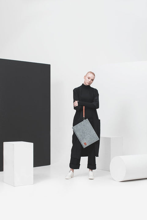 1. Unisex grey Nordhale Berg 15'' laptop bag worn by a model in a minimalist studio setting