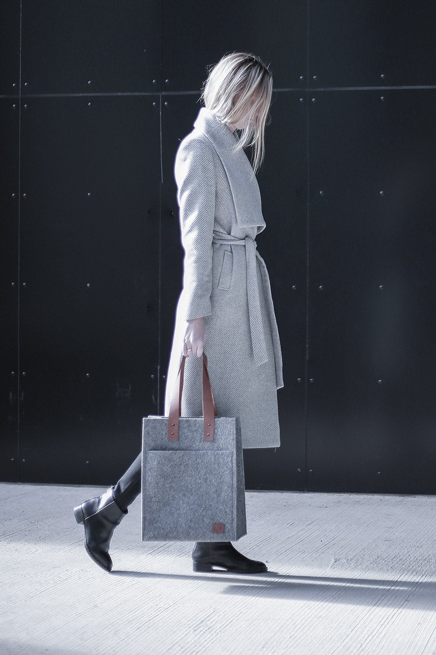 3. Woman walking in grey coat with Nordhale Hennes Tote Bag in grey, highlighting versatile style