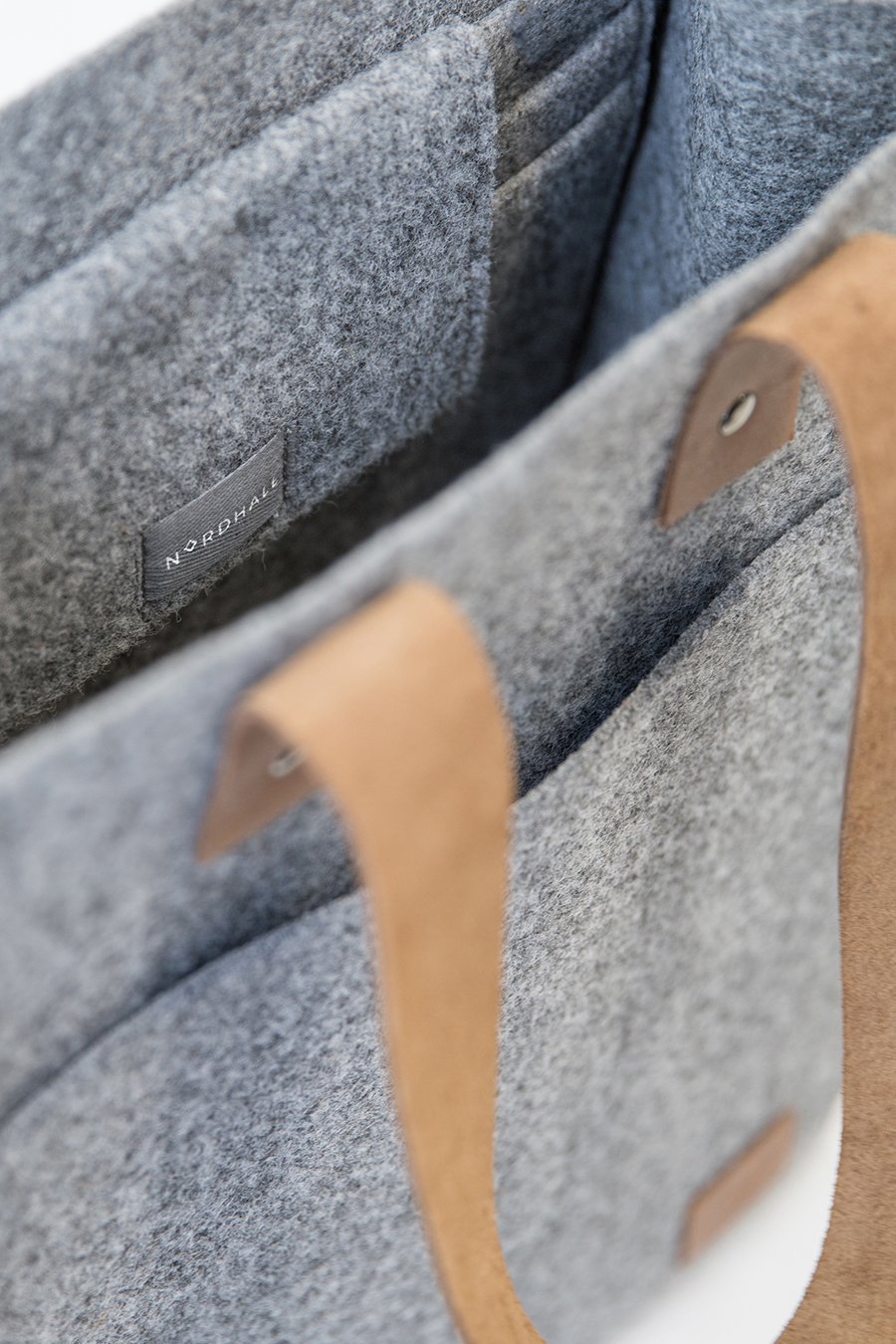 6. Close-up of Nordhale Hennes Tote Bag in grey, highlighting brand label and felt texture
