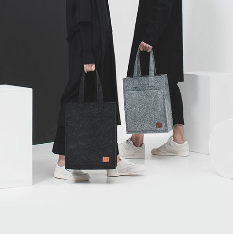 2. Unisex grey Hof Tote Bag by Nordhale, held by models in a modern studio setting