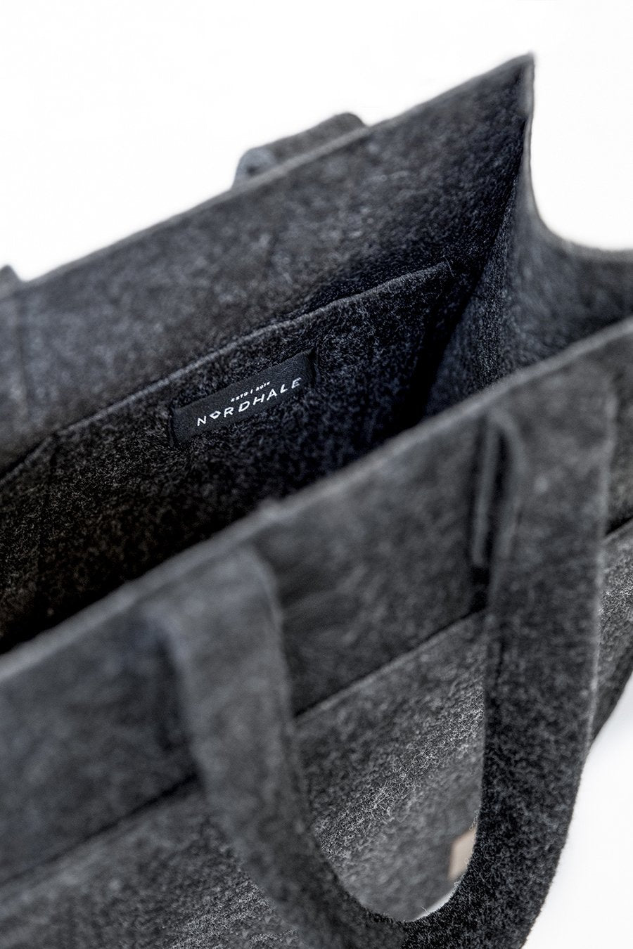 6. Close-up of Nordhale Hof Tote Bag interior, featuring recycled PET felt material and brand label