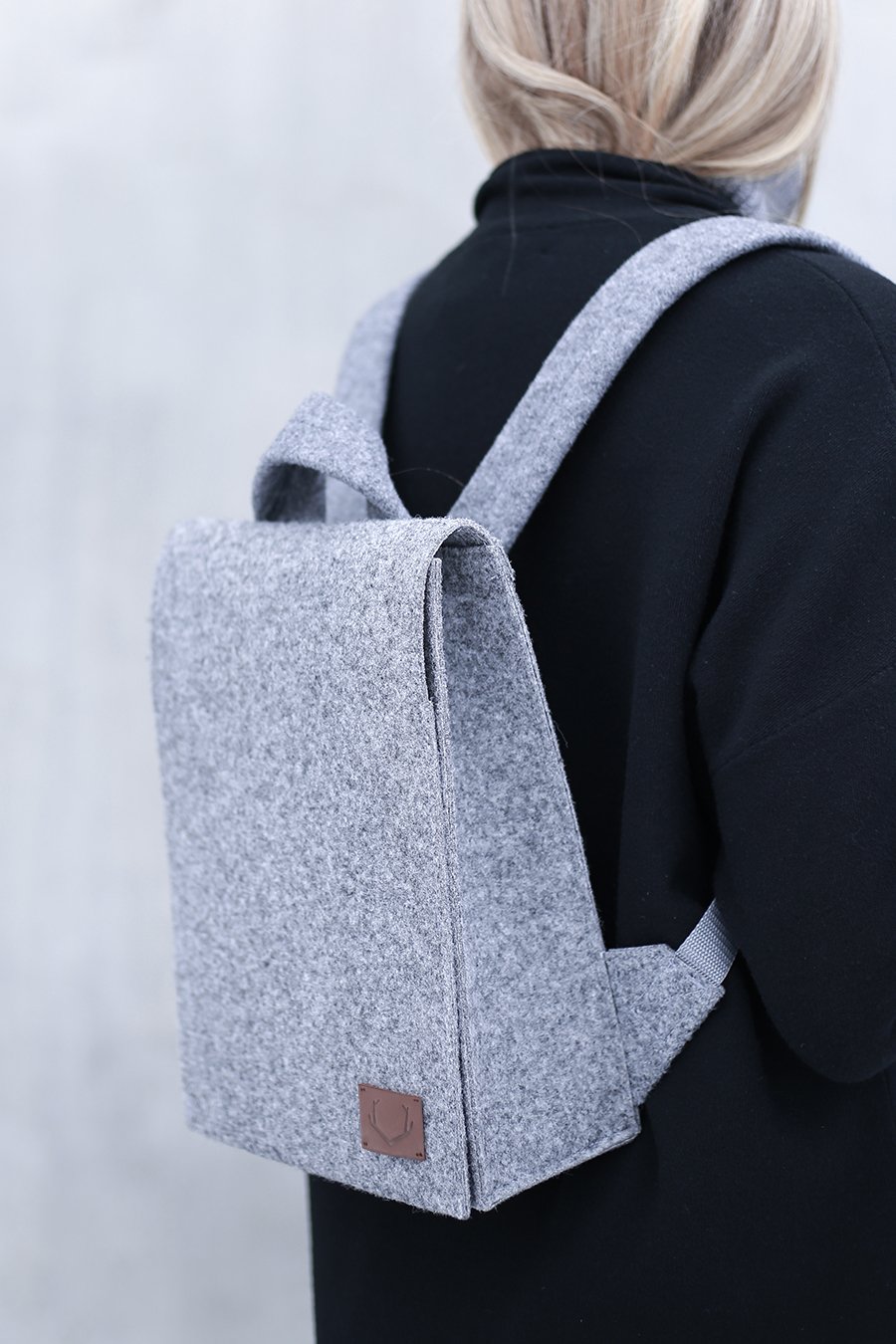 3. Side view of woman wearing Nordhale Lund Mini Backpack in grey, highlighting adjustable straps