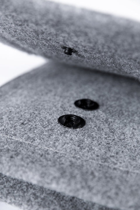 1. Woman wearing Nordhale Backpack Lund in grey on a beach, showcasing unisex design and minimalist style