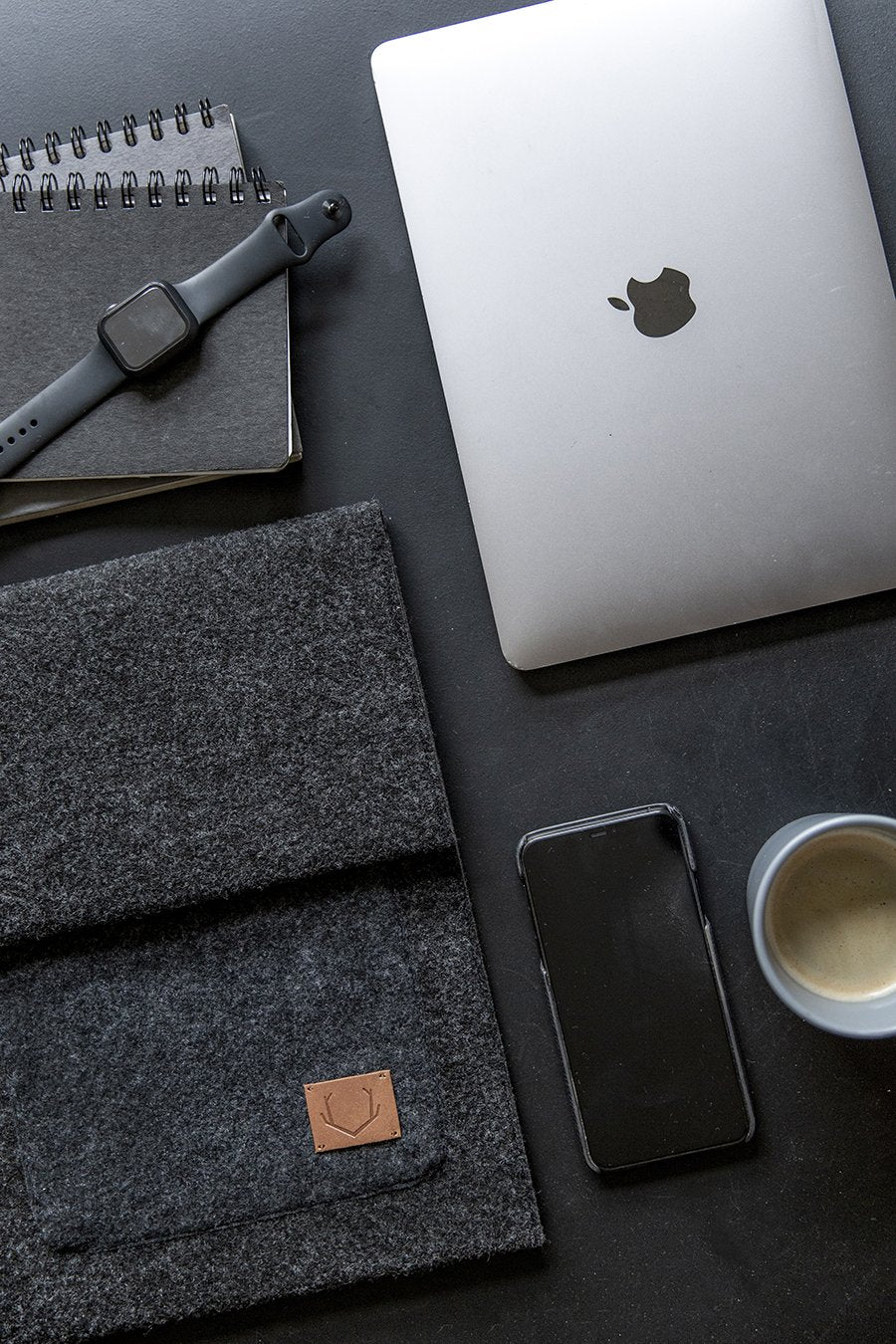 2. Flat lay of Nordhale Malmö black laptop sleeve with MacBook and accessories