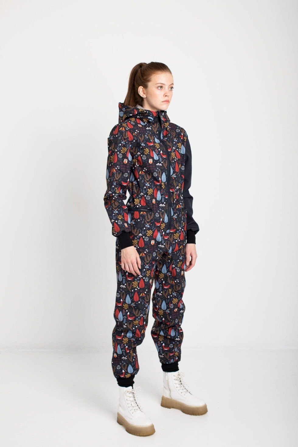 1. Women's EBEKAI softshell overall by Nuckö in studio, showcasing digital print pattern and adjustable hood