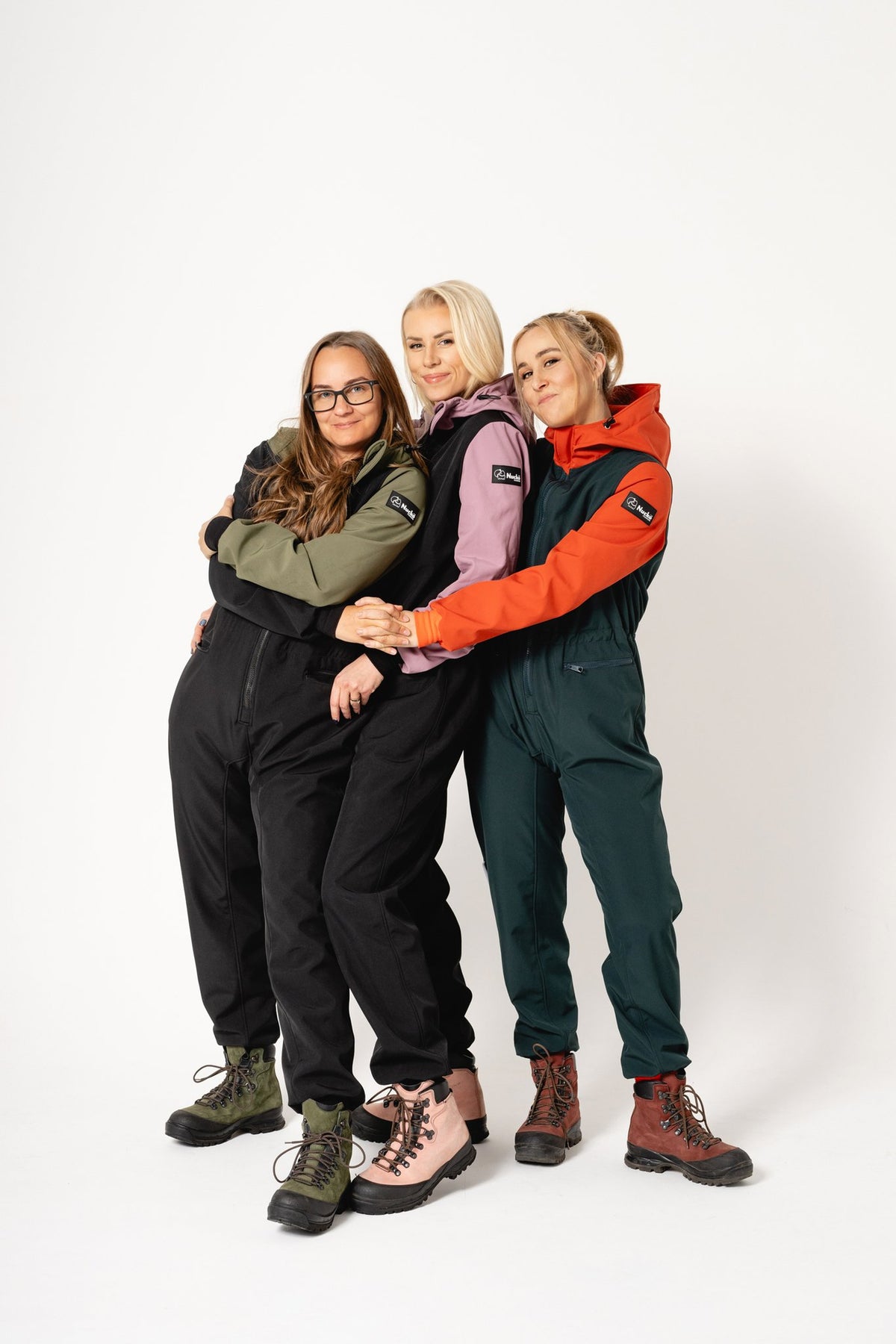 1. Women's Kristel softshell overalls by Nuckö in various colors worn by three models in studio setting