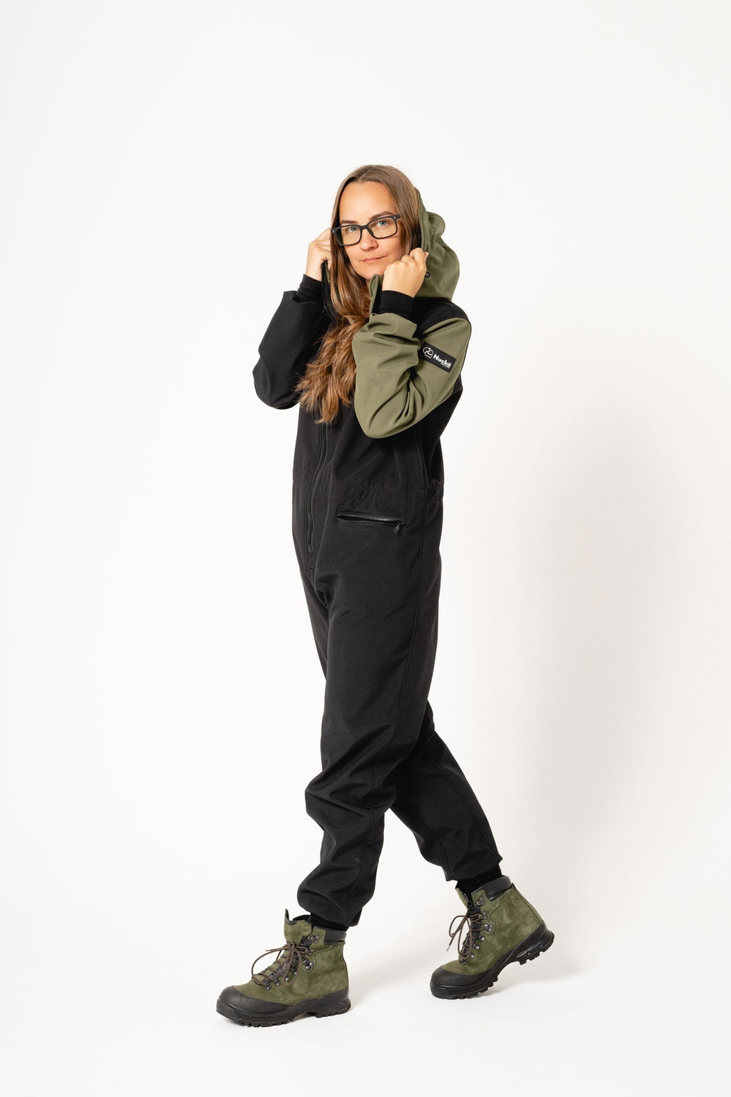 2. Women's CAROLA softshell overall by Nuckö in black and green, shown with adjustable hood in studio