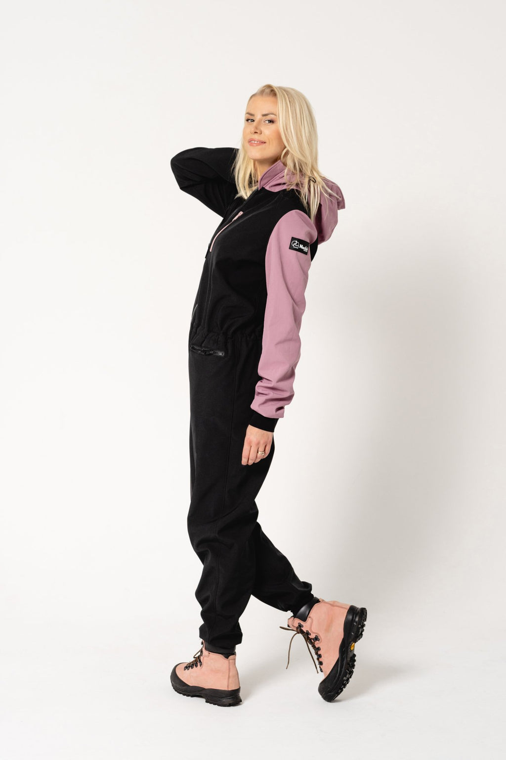 3. Women's Eeva softshell overall by Nuckö in black and pink, side view in a studio setting